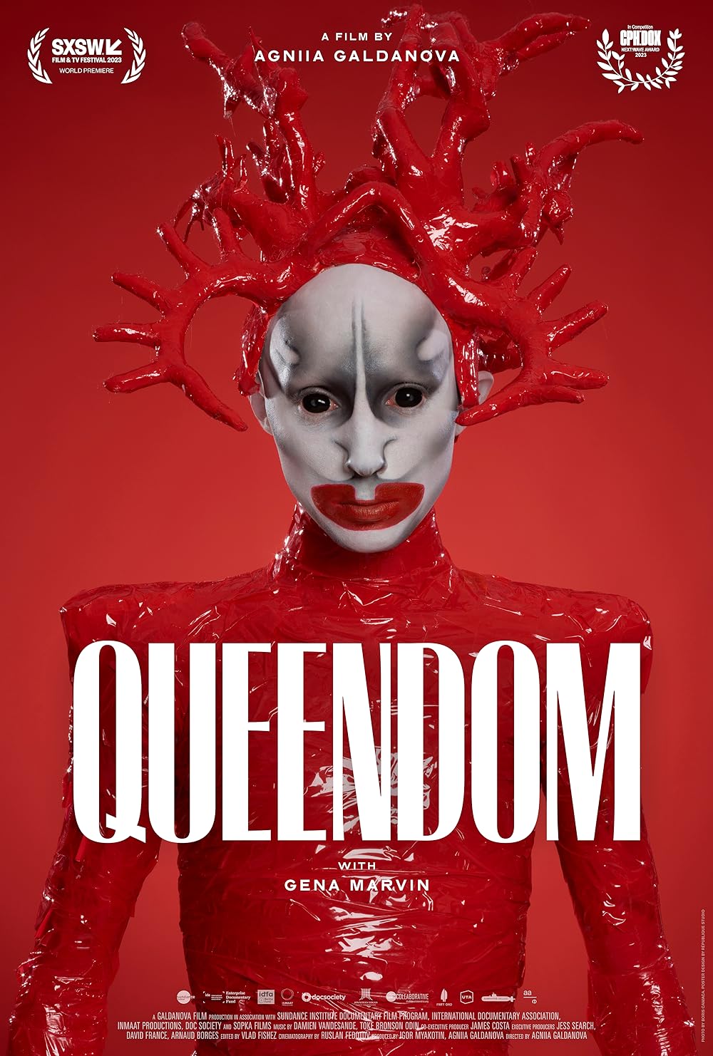 person dressed in red with white striking face makeup with red background. White text overlayed with 'queendom'